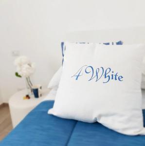 a pillow with a bite written on it sitting on a bed at FOUR WHITE APARTMENTS in Agerola