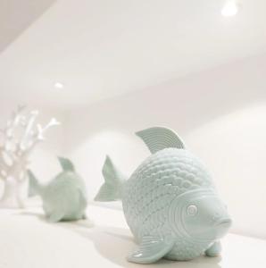阿傑羅拉的住宿－FOUR WHITE APARTMENTS，猫旁边一只白色的塑料鱼玩具