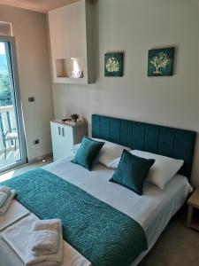 a bedroom with a large bed with a green headboard at Vila Jadranka Apartments in Herceg-Novi