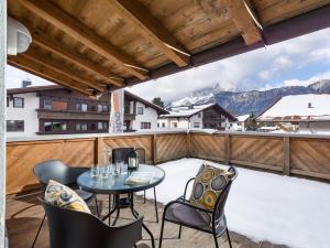 een patio met een tafel en stoelen op een balkon bij KS - Suiten in Sankt Johann in Tirol