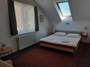 - une chambre avec un lit, 2 fenêtres et une chaise dans l'établissement Dworek Natury, à Strzezenice
