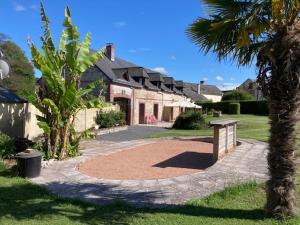 a house with a palm tree in front of it at Le gîte de SoleilMapou pour 12 personnes en Normandie près de Fécamp et d'Etretat, idéal grandes tribus, vous pouvez me joindre au zéro six soixante dix huit soixante treize trente six quatre vingt onze pour réserver en direct in Ganzeville