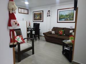 ein Wohnzimmer mit einer Santa Claus Dekoration auf einem Stuhl in der Unterkunft La Casa de Mamá Tere in Zapatoca