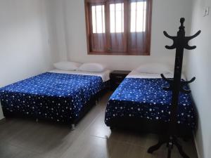 2 Betten nebeneinander in einem Zimmer in der Unterkunft La Casa de Mamá Tere in Zapatoca