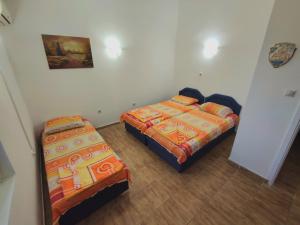 een kamer met 2 bedden en een nachtkastje bij Apartmani Durovic in Bar +9 foto's