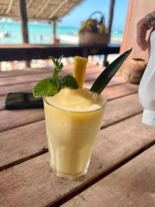 a drink sitting on top of a wooden table at Hotel and Beach Club Escape Holbox in Holbox Island