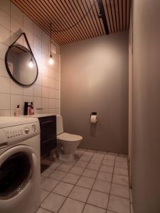 a bathroom with a washing machine and a toilet at Cozy apartment by the sea in Tromsø