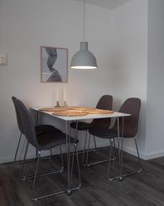 a dining room table with chairs and a lamp at Cozy apartment by the sea in Tromsø