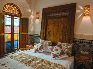 Un dormitorio con una cama con almohadas. en Riad Fès Center, en Fez