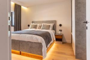 a bedroom with a large bed and a wooden floor at Plaza Apartments in Sarajevo