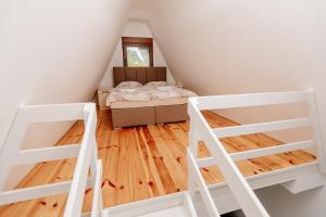 a attic bedroom with a bed and two ladders at Bungalow Holiday in Pluzine