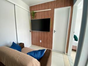 a living room with a couch and a flat screen tv at Temporada 737 in Aracaju