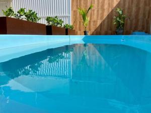 a blue swimming pool with a reflection in the water at Temporada 737 in Aracaju