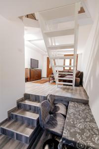 a living room with stairs and a chair and a table at Bungalow Holiday in Pluzine