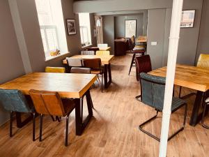 un restaurante con mesas de madera y sillas en una habitación en Severn Valley Guest House en Bewdley