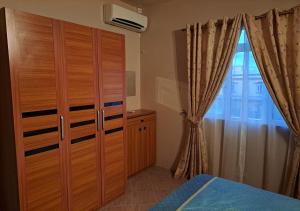 a bedroom with a wooden cabinet and a window at Lukshvilla private villa Le morne wind n kite surfers accomodation & car rental mauritius in La Gaulette