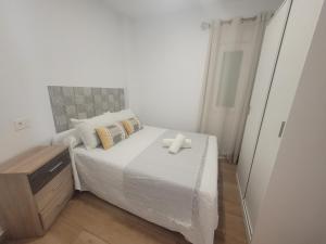 a small bedroom with a bed with a cross on it at Alojamiento Paco Cabrera in Almuñécar