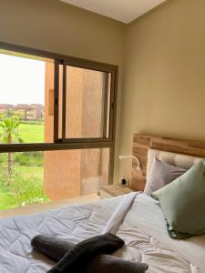 - une chambre avec un lit et une grande fenêtre dans l'établissement Prestigia Golf, à Marrakech