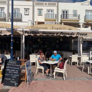two people sitting at a table outside a restaurant at Mogán suite in Puerto de Mogán