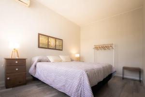 een slaapkamer met een bed en een dressoir met een nachtkastje bij Casa Huarpe in Mendoza