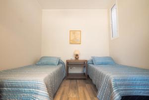 twee bedden naast elkaar in een kamer bij Casa Huarpe in Mendoza +8 foto's