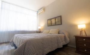 een slaapkamer met een bed, 2 lampen en een raam bij Casa Huarpe in Mendoza