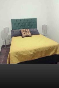1 dormitorio con 1 cama con cabecero verde y 2 lámparas en Lovely and warming 3 bed, en Morelia