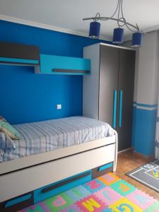 Un dormitorio con una cama con una pared azul. en Keymar, en San Miguel de Meruelo 19 fotos más