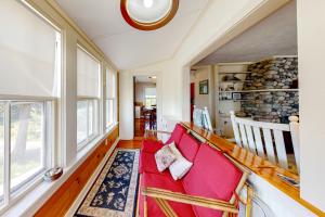 a living room with a red couch and a large window at Retreat Cottage in Plymouth