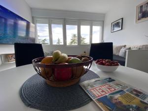 un bol de fruta en una mesa junto a una revista en Apartment Centar Višnjik, Zadar en Zadar
