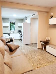 uma sala de estar com um sofá e um frigorífico branco em Apartamento Luz em Valência