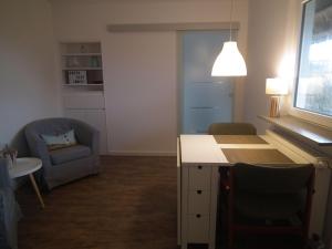 sala de estar con silla, mesa y sofá en Haus-Marina, en Rantum