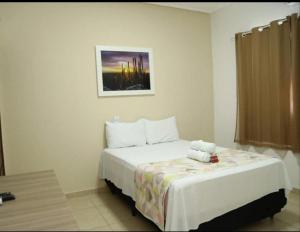 a bedroom with a bed with a teddy bear on it at Canions Pousada in Canindé de São Francisco +13 photos