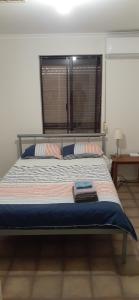 a bedroom with a large bed with a window at Cartledge Ave studio and house homestay in Whyalla +1 photo