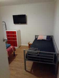 Schlafzimmer mit einem Bett und einem Flachbild-TV in der Unterkunft Cartledge Ave house accommodation Whyalla in Whyalla