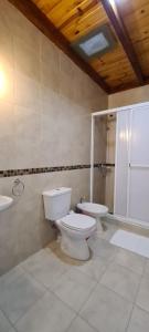 uma casa de banho com 2 WC, um chuveiro e um lavatório. em Pai Pajarito em Corrientes