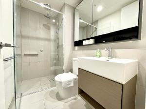 een badkamer met een toilet, een wastafel en een douche bij Readyset Apartments at Marque in Melbourne