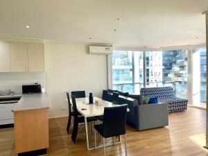 墨爾本的住宿－Readyset Apartments at Dockside，厨房以及带桌椅的起居室。