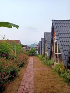 a row of houses with a brick pathway in a garden at Homestay Bình Huy in Mộc Châu