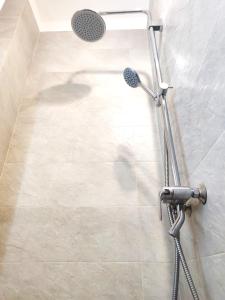 a shower with a shower head in a bathroom at Loftik Apartments Gagarin street in Almaty