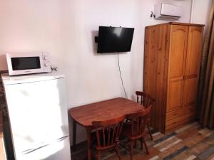 eine Küche mit einem Tisch, einer Mikrowelle und einem Kühlschrank in der Unterkunft Loftik Apartments Gagarin street in Almaty