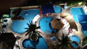 an overhead view of a swimming pool with palm trees and umbrellas at 504-AP-com bebidas liberadas no parque aquatico e internet banda larga in Caldas Novas