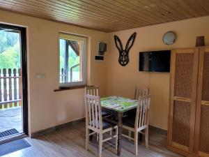 a dining room with a table and chairs and a tv at Domki u Gretka in Lutowiska