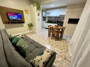 佛羅安那波里的住宿－Residencial Bernardo 1 dormitório，客厅配有沙发和餐桌,厨房配有桌子