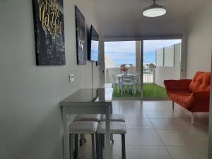 ein Wohnzimmer mit einem Tisch, Stühlen und einem Sofa in der Unterkunft Monarca House, Senator in Costa Teguise