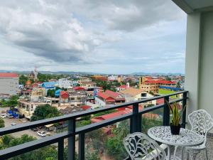 a balcony with a table and chairs overlooking a city at Kampot Sunny Hotel in Kampot