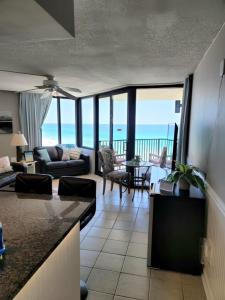 a kitchen and living room with a view of the ocean at Beachfront Condo Panama City Beach Gulf Front Views walk to Pineapple Willy's in Panama City Beach