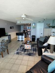 a living room with a couch and a table at Beachfront Condo Panama City Beach Gulf Front Views walk to Pineapple Willy's in Panama City Beach