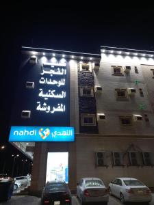 ein Schild an der Seite eines Gebäudes in der Nacht in der Unterkunft نسيم الفجر للشقق المخدومة in Dschidda
