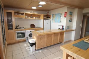 uma cozinha com armários de madeira e uma máquina de lavar e secar roupa em The Jetty at Cowan Cowan em Cowan Cowan